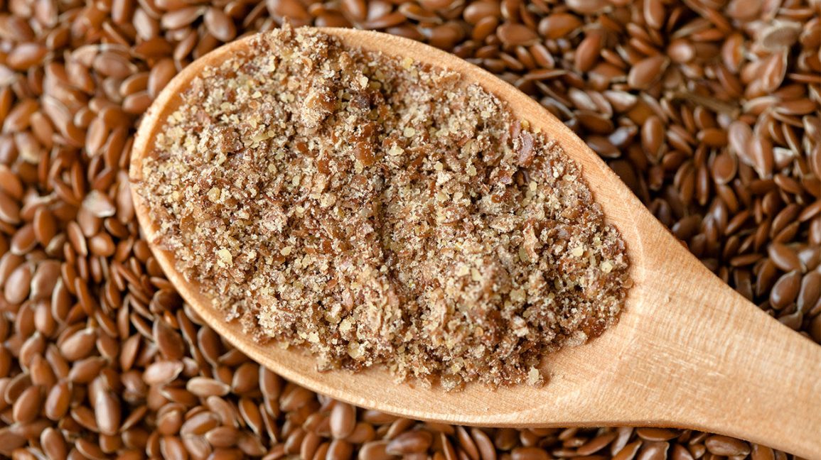 ¿Cuál es la mejor forma de moler linaza? Linaza y cuchara de madera con semillas de lino molidas