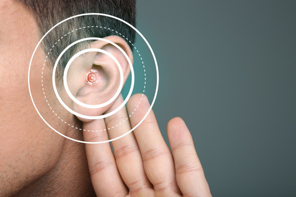 hombre con la mano en la oreja para indicar pérdida de audición