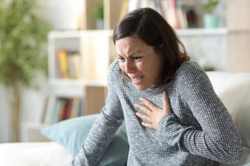 A tormented woman se lleva la mano al pecho – Fuente: Depositphotos